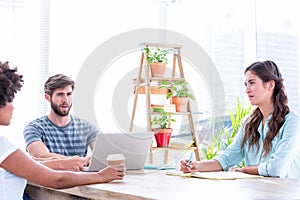 Creative business people using laptop in meeting