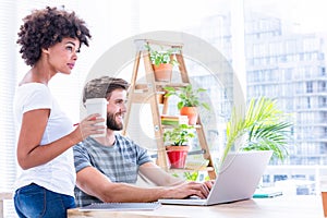 Creative business people using laptop in meeting