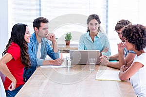 Creative business people using laptop in meeting