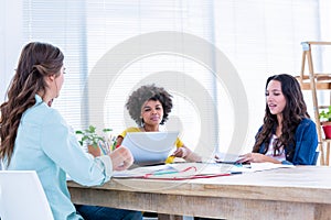 Creative business people using laptop in meeting