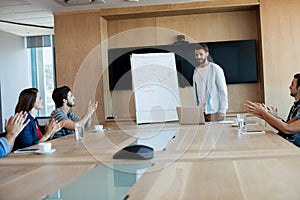 Creative business team applauding while attending a presentation