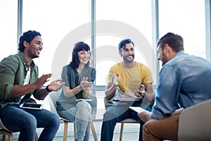 Creative business team applauding for their colleague in office