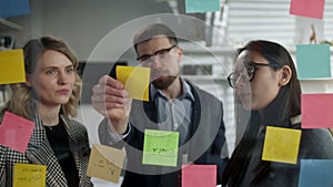 Creative Business Team Brainstorming Ideas Working Together Near Glass Wall With Sticky Notes. Colleagues approve