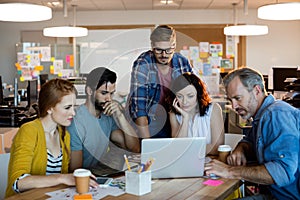 Creative business team discussing over the laptop