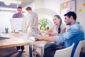 Creative business team gathered around laptops