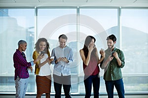 Creative business team interacting while using mobile phone