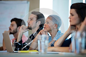 Creative business team listening at meeting in conference room