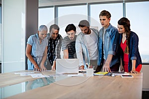 Creative business team looking at presentation in laptop