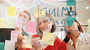 Creative business team sharing idea, writing down on sticky note. Immaculate.