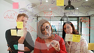 Creative business team sharing idea, writing down on sticky note. Immaculate.