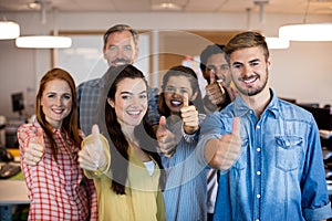 Creative business team showing thumbs up at office