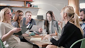 Creative business team at the table in a modern startup office. Female leader explains the details of the project.