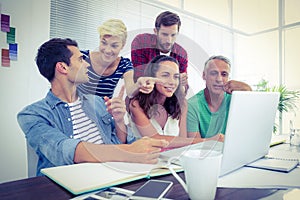 Creative business team using laptop in meeting