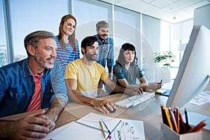 Creative business team working together on desktop pc