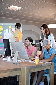 Creative business team working together on desktop pc
