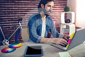 Creative businessman using using laptop by graphic tablet on desk