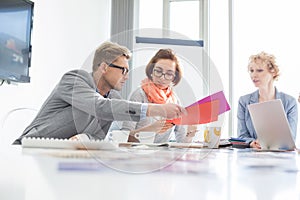 Creative businesspeople analyzing documents at desk in office