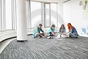 Creative businesspeople working on floor in office