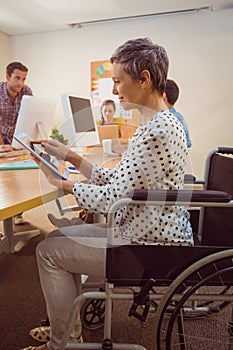 Creative businesswoman in wheelchair using a tablet