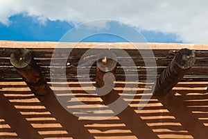 Creative cast shadows from vigas and latillas on exterior adobe wall