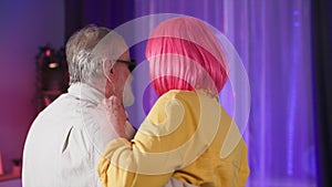 creative cheerful elderly man and old woman having fun dancing at a senior party in cozy room