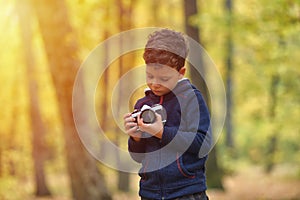 Creative child, kid photographer a little boy with a camera ta