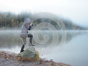 Creative child, kid photographer a little boy with a camera taking landscape pictures near la lake