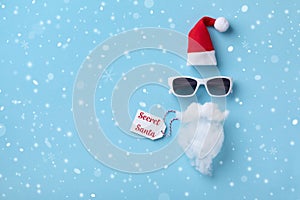 Creative Christmas background. Secret Santa card. Santa Claus hipster with hat, beard and sunglasses