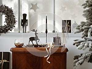 Creative christmas composition on the vintage shelf in the living room interior with beautiful decoration, big window, christmas