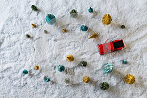 Creative Christmas decoration with red truck and colorful snowy spruces in the snow. Winter forest. Aerial, top view. Flat lay.