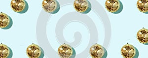 Creative Christmas pattern. Frame with shiny gold disco balls over blue background. Flat lay, top view. New year baubles