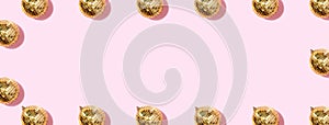 Creative Christmas pattern. Frame with shiny gold disco balls over pink background. Flat lay, top view. New year baubles