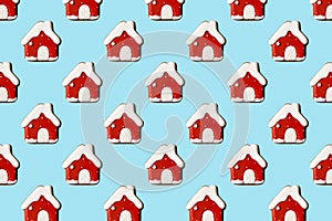 Creative Christmas pattern with red houses on pastel blue background, copy space. Minimal, winter, new year concept.