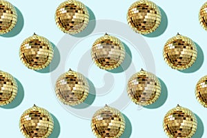 Creative Christmas pattern. Shiny gold disco balls over blue background. Flat lay, top view. New year baubles, star