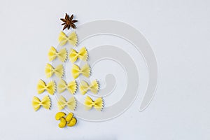 Creative Christmas tree made of pasta pasta on gray background. The concept of creative Christmas cuisine, children`s creativity.