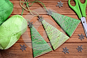 Creative Christmas trees ornaments on a wooden background. Festive Christmas activity for preschoolers. Kids workplace. Top view