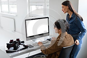 Creative collaboration concept. Photographer and his female assistant checking and discussing photos on computer, mockup