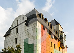 Creative colorful exterior of the commercial lowrise townhouse building architecture with a ventilate facade and loft mansard roof photo