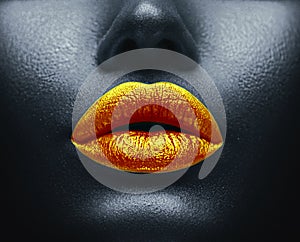 Creative colorful makeup. Bodyart, lipgloss on sexy lips, girls mouth. Golden lips on black skin photo