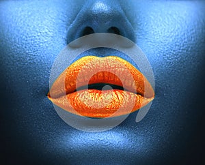 Creative colorful makeup. Bodyart, lipgloss on sexy lips, girls mouth. Orange lips on blue skin