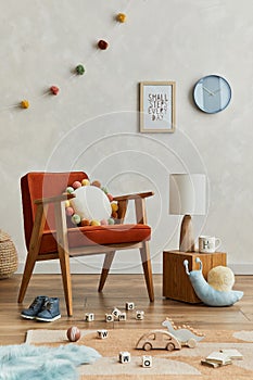 Creative composition of cozy scandinavian child`s room interior with mock up poster frame, red armchair, plush toys and hanging.