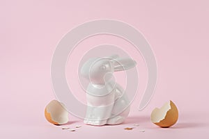 Creative composition with Easter bunny or rabbit with a broken egg shell. Minimal holiday concept
