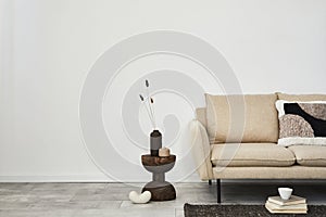 Creative composition of elegant living room interior. Beige modern sofa, vintage side table and stylish personal accessories.