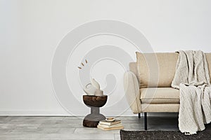 Creative composition of elegant minimalist living room interior. Beige modern sofa, dar wooden side table.