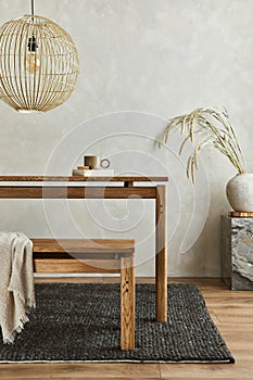 Creative composition with elegant wooden dining table. Beautiful home decorations and accessories. Modern home interior design.