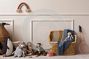 Creative composition of kids room interior with wicker basket, plush animal toys, plaid, wooden blockers, ornament on wall, beige