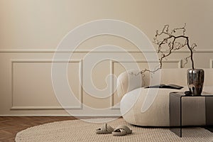 Creative composition of living room interior with copy space, white sofa, chrom vase with branch, glass coffee table, round rug,