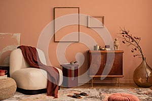 Creative composition of living room interior with mock up poster frame, wooden sideboard, beige armchair, plaid, vase with rowan,