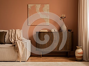 Creative composition of living room interior with mock up poster frame, wooden sideboard, modular beige sofa, brown pouf, plaid,
