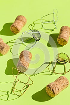Creative composition made of champagne corks on green sunlit background with shadow. Bottle caps from sparkling wine and metal